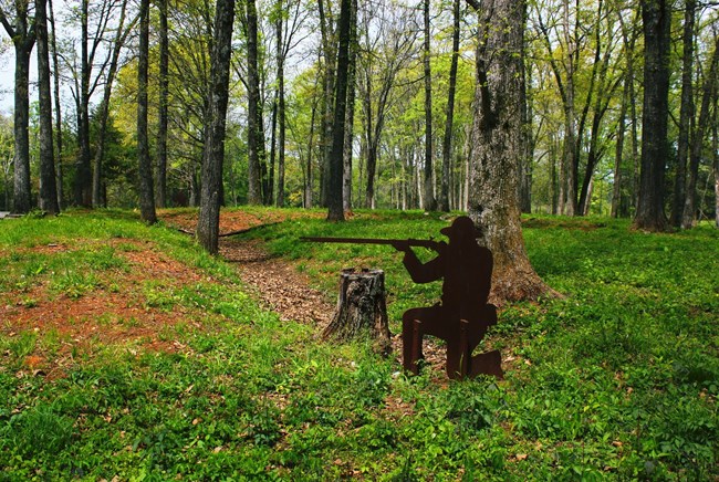 Brown silhouette of kneeling Civil War soldier inside of trenches