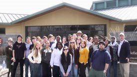 Group of students and rangers in front of the park visitor center.