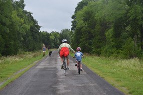 Bicyclists pass joggers on the park tour road. Bicyclists pass joggers on the park tour road.
