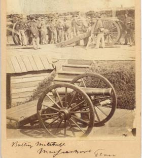 Men standing with cannons behind earthworks