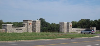 A car enters the park through the stone pillars of the main gate. A car enters the park through the stone pillars of the main gate.