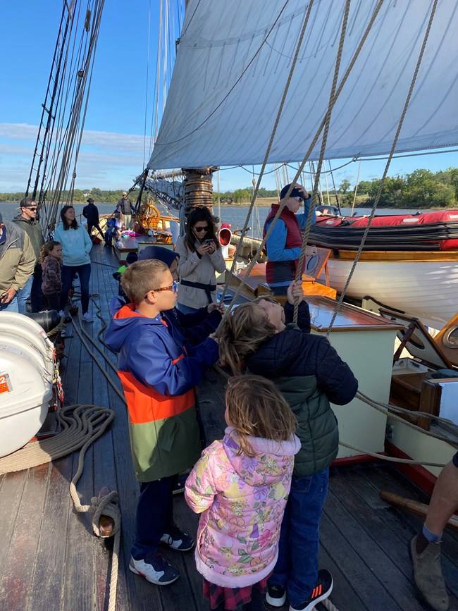Children help pull ropes on the Pride of Baltimore II.