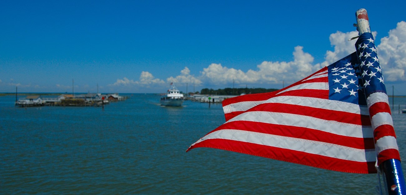 Photograph of an American flag waving over the waters of the Chesapeake Bay.