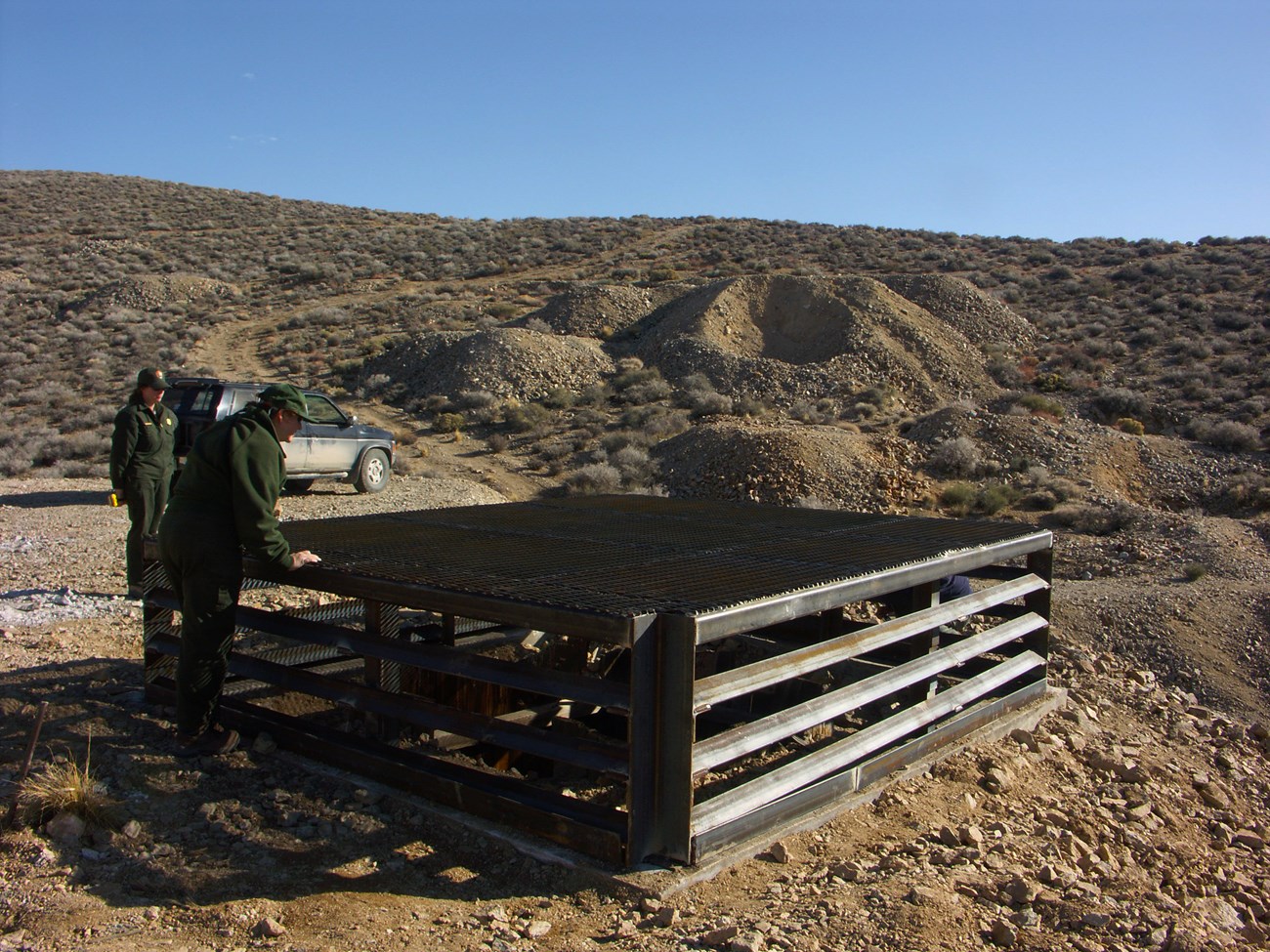 two people examine a mine shaft with a bat cupola