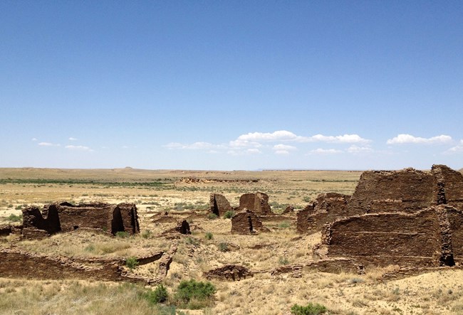 View from Kin Bineola at Chaco Culture National Historical Park, New Mexico. A distant view with ancestral Puebloan buildings in the foreground.