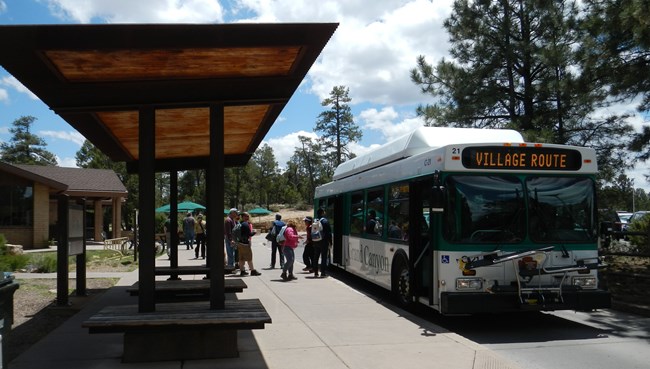 Photo of park visitors preparing to board a shuttle bus at Grand Canyon National Park, Arizona.