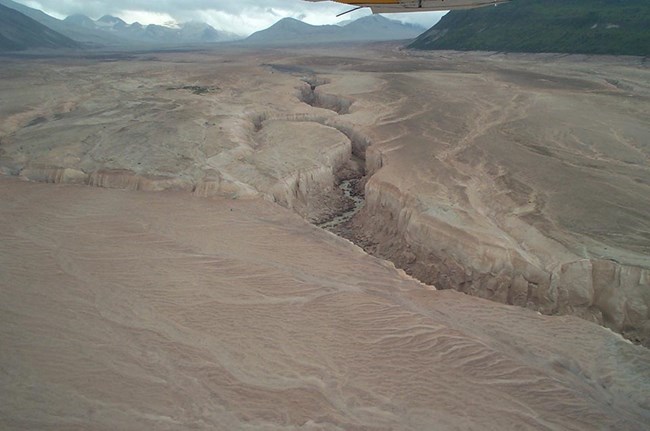 Deep erosion cuts through volcanic ash and soil in Katmai's Valley of Ten Thousand Smokes. Deep erosion cuts through volcanic ash and soil in Katmai's Valley of Ten Thousand Smokes.