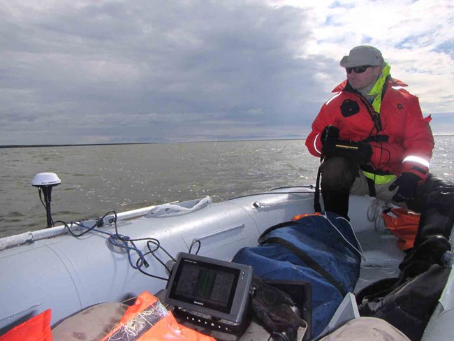 Hydrologist Paul Burger, hydrologist, collects data in an Arctic lagoon.