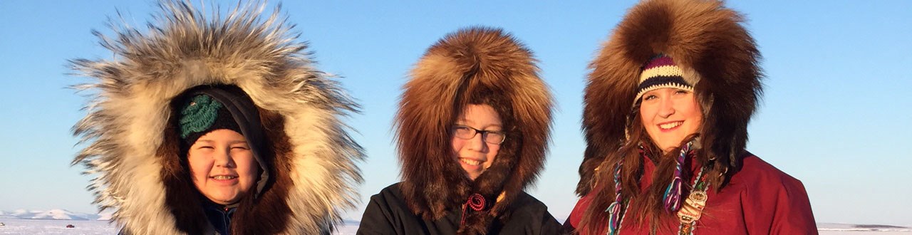 Three young women pose in the Alaska winter sun.