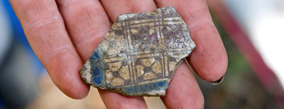Archeologist holds ceramic sherd. Archeologist holds ceramic sherd.