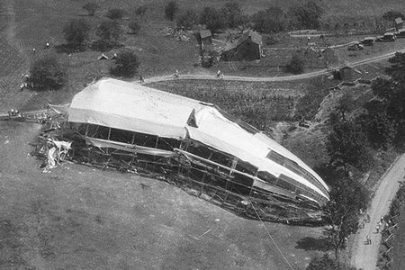 USS Shenandoah Crash Site A wrecked part of an airship lays in a field with steel skeleton exposed, resting near a line of trees