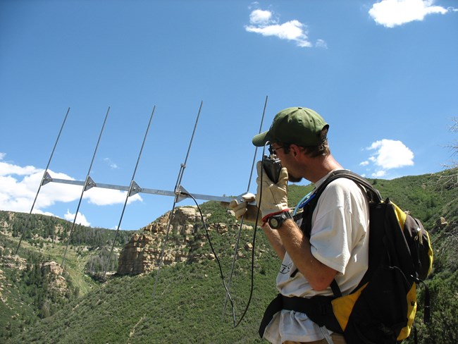 man holds radiotransmitter outdoors