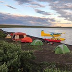 tents and float plane on lakeshore