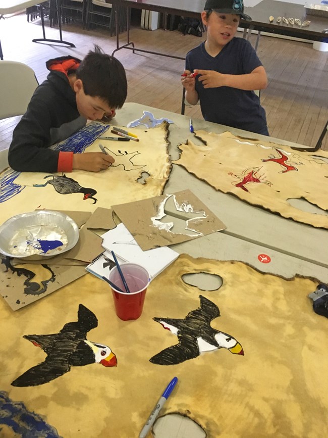 children draw birds on seal skin