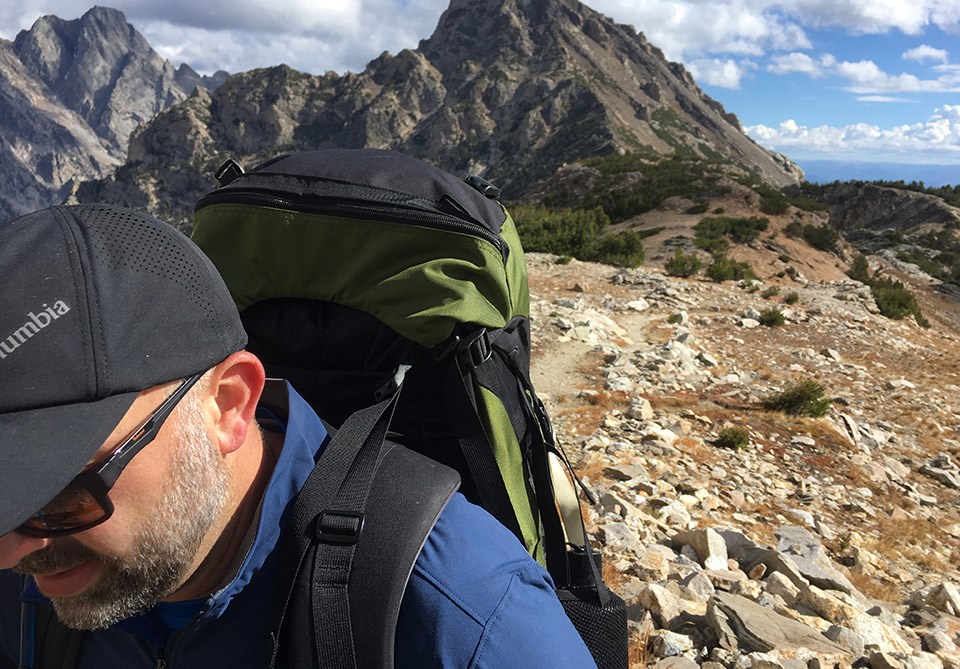 David Restivo hiking with mountains in the background