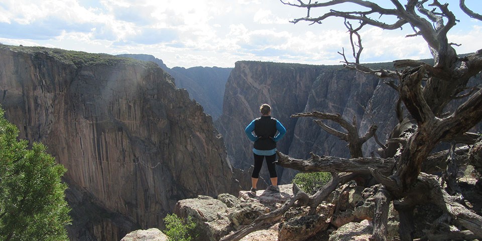 allie standing on a cliff looking out at a vast rocky canyon