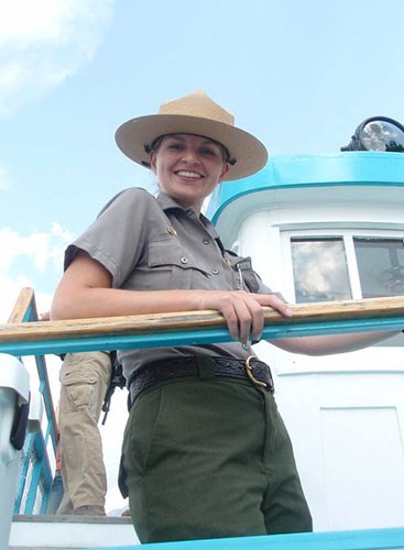 image1_500 young woman in a ranger uniform smiles and looks down from a platform