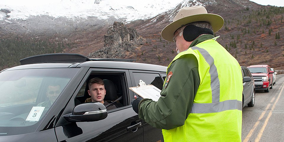 A park ranger talks to visitors in a car