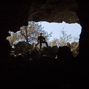 person standing in cave entrance