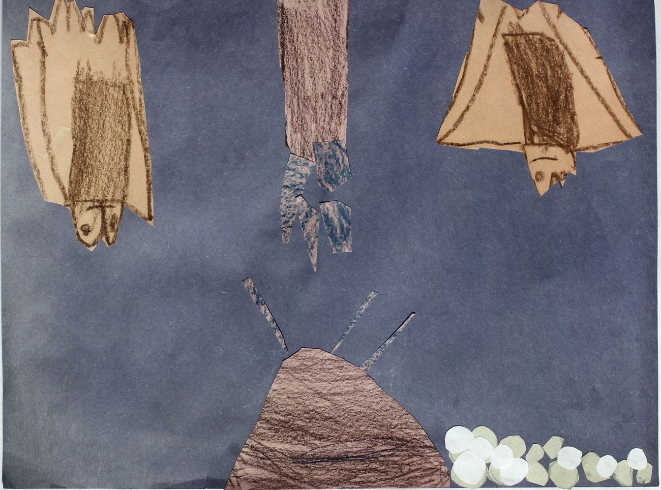 Cave scene featuring bats in colored paper collage and crayon