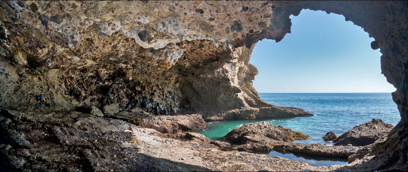 view looking out to sea from the entrance area of a large sea cave