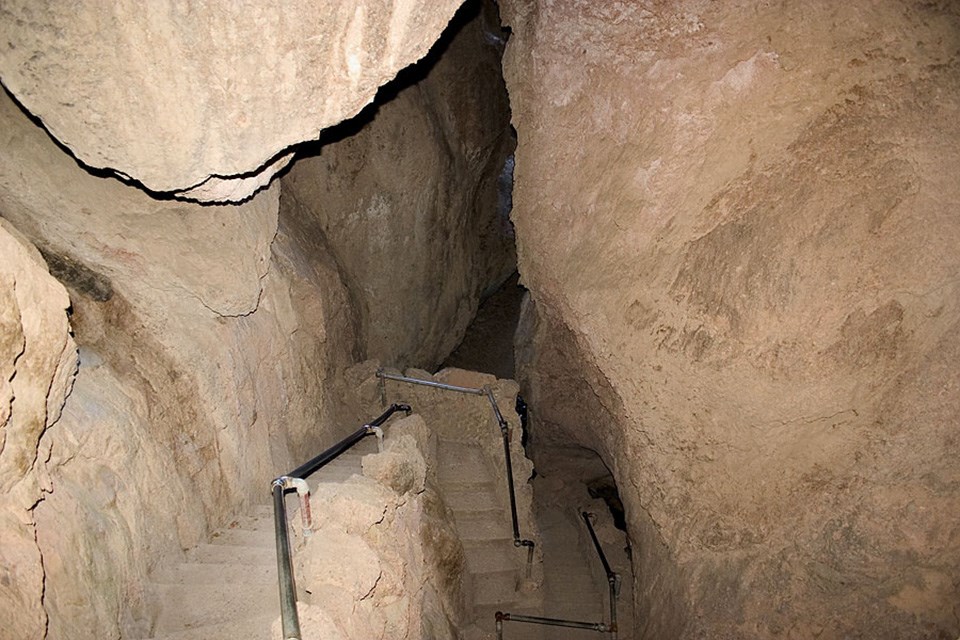 trail with steps and handrail winding through talus cave