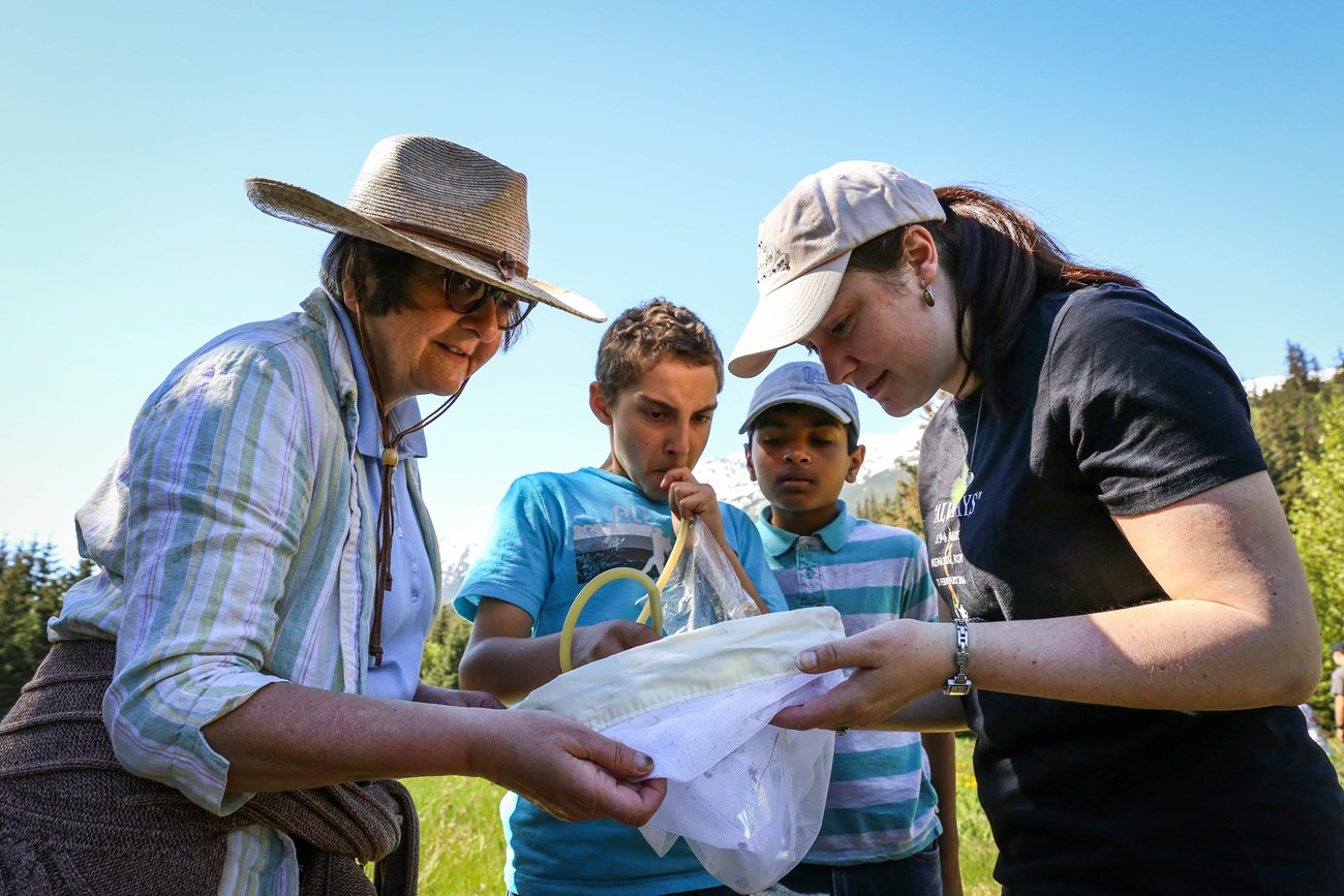 Two adults and two kids gather around a net