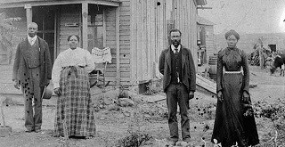 exoduster historic photo of four people standing in front of a building