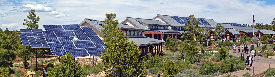 Solar panel arrays are seen on top of, and around, a large visitor center