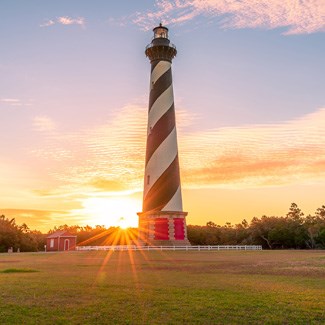 Sunset is seen behind the Cape Hatteras Lighthouse at Cape Hatteras National Seashore