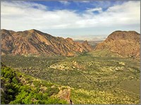 Aerial view of a verdant valley with mountains in the background