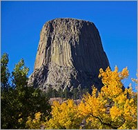 View of Devils Tower in the distance with fall foliage in the foreground