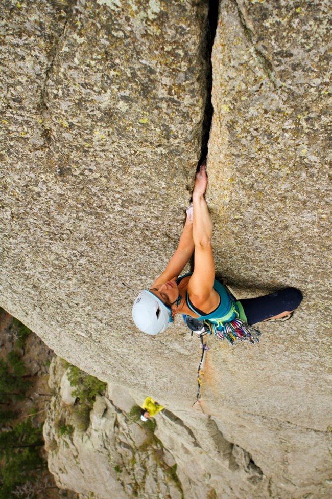 View from above of female climbing steward ascending Devils Tower