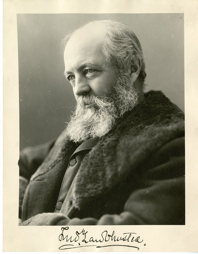 Portrait of Frederick Law Olmsted, Sr., a man with a coarse beard and a thick coat.