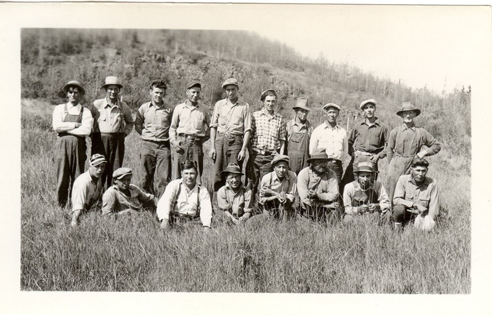 1000_GRPO 1322 Historic photo of two rows of men in work clothes, a row on the grassy ground in front of a standing row