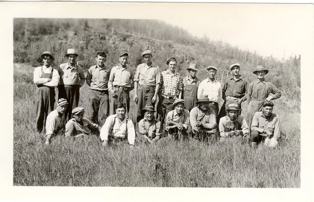 1000_GRPO 1322 Historic photo of two rows of men in work clothes, a row on the grassy ground in front of a standing row