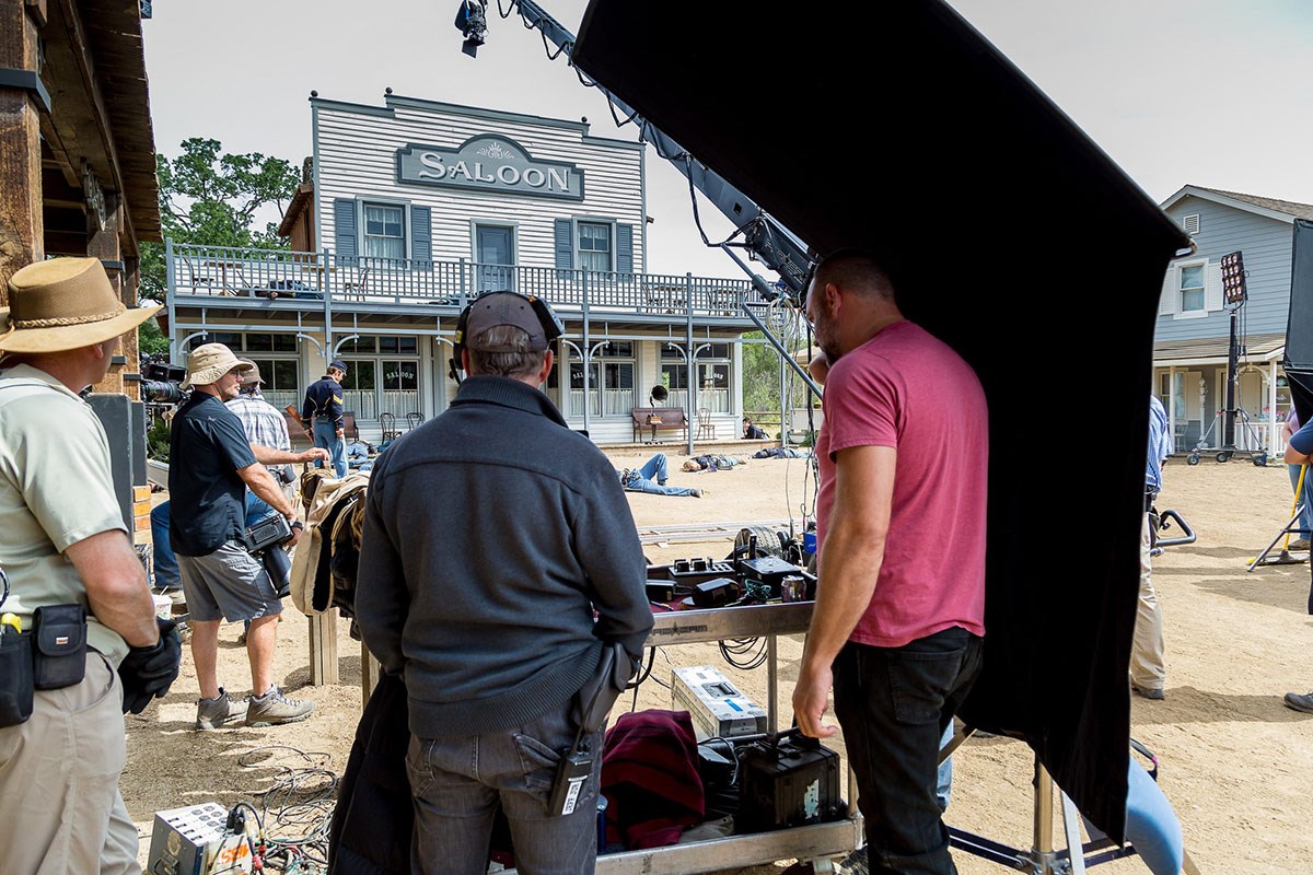 Production crew members with their recording gear in a western town setting