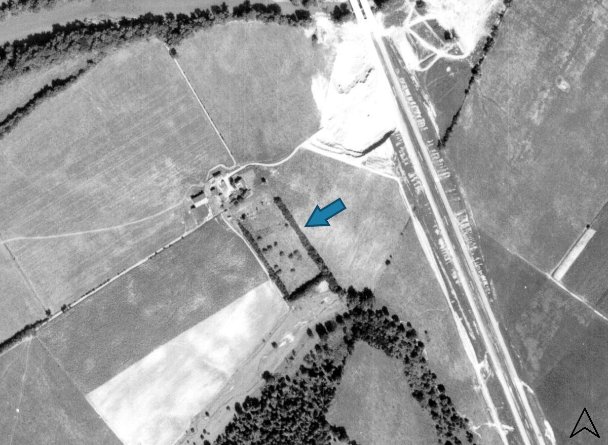 Aerial view of farm with an arrow pointing at a row of trees