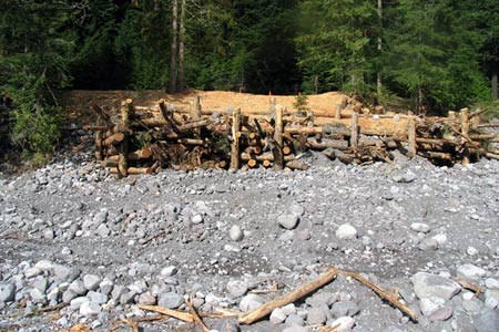 A structure of logs on a rocky embankment in Mount Rainier National Park