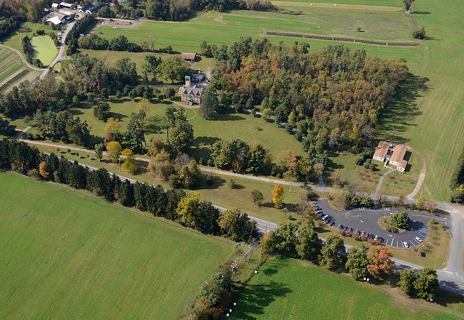 Aerial view of Martin Van Buren National Historic Site, with a house and designed landscape features  surrounded by agricultural fields (