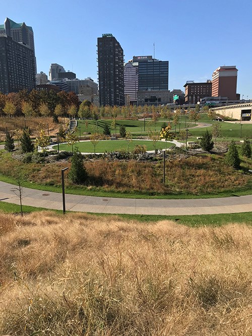 The National Expansion Memorial landscape merges grasses, trees, open turf, and curving walkways