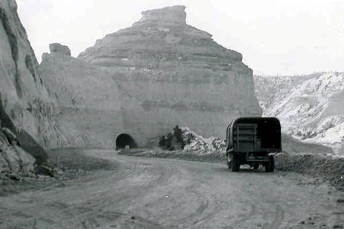 A truck on a dirt road, which is being graded between the first and second tunnels of the Summit Road at Scotts Bluff National Monument