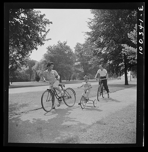 Two adults and a child cycle on a trail at East Potomac Park, 1942