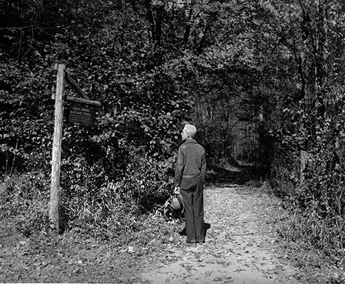 A hiker reads a sign as he stands at the entrance to Rock Creek Nature Trail