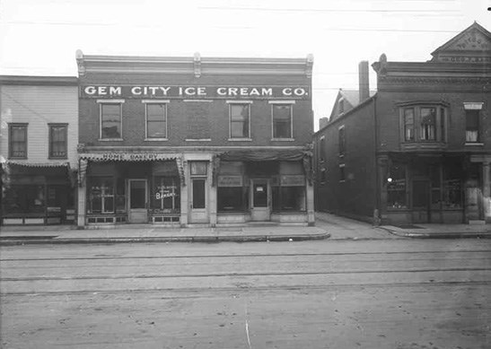 Two-story brick building with awnings says "Gem City Ice Cream Co." across the top of the facade, 1910