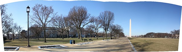 Panorama of the Mall landscape, looking west towards the Washington Monument Benches and trees line a broad walkway, through a level turf area towards the Washington Monument.