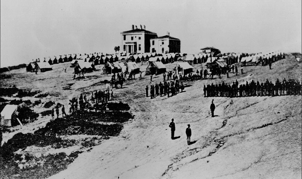 Troops stationed at the armory superintendent's house in 1862, showing a bare and compacted earth.