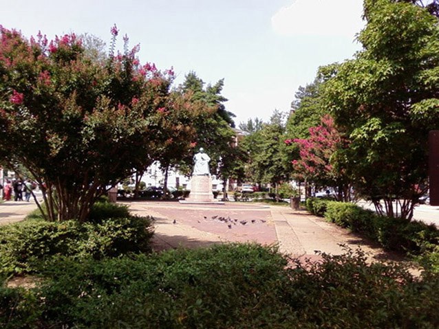 View east of US Reservation 309 G, where rows of manicured shrubs and blooming crepe myrtles frame the view of the statuary.