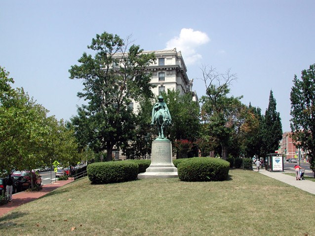 Two historic ash trees frame the memorial and screen the Kennesaw Apartments.