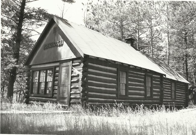 Boekelodge Cabin 1970s One-story cabin with saddle notched logs, a gable roof, and the word "Boekelodge" over the front door and windows.